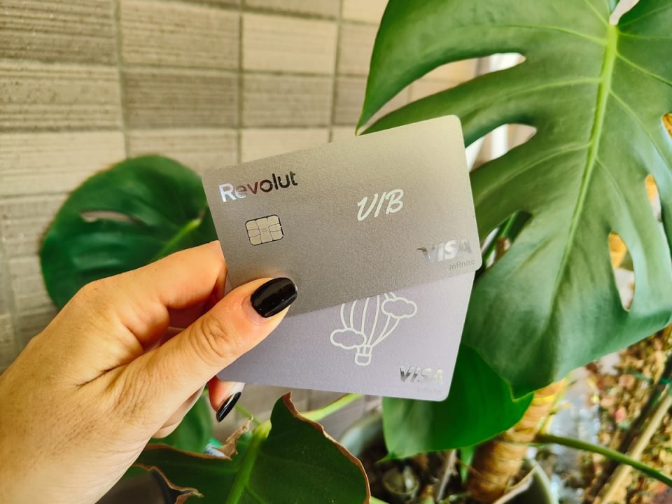 Foto raffigurante una mano di donna che mostra due carte di debito Revolut