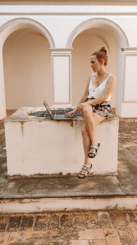tursi digital nomads Donna con laptop seduta su un pozzo nell'atrio dell'antico monastero di tursi ora adibito a coworking